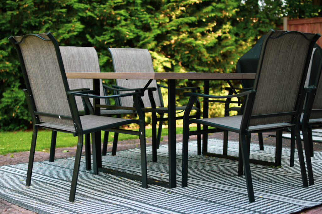 Outdoor dining set with aluminum frame and Teslin fabric, featuring one table and six chairs.