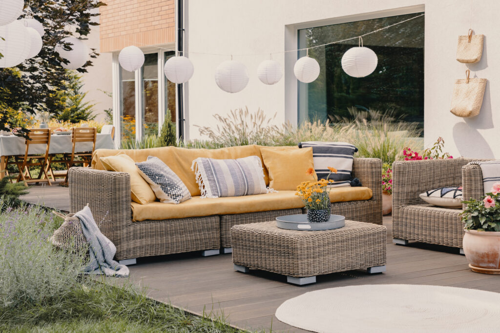 Rattan garden sofa set with colorful cushions, showcasing timeless craftsmanship and festive outdoor ambiance