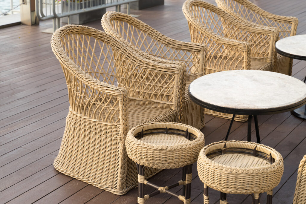 Classic PE rattan chair on a sunlit terrace.
