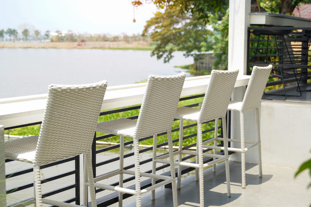 White woven rattan chair designed for outdoor bar seating.