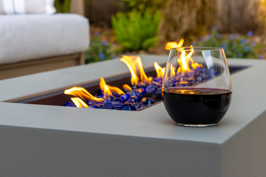 Modern outdoor gas fireplace table in a garden, providing warmth, elegance, and ambiance