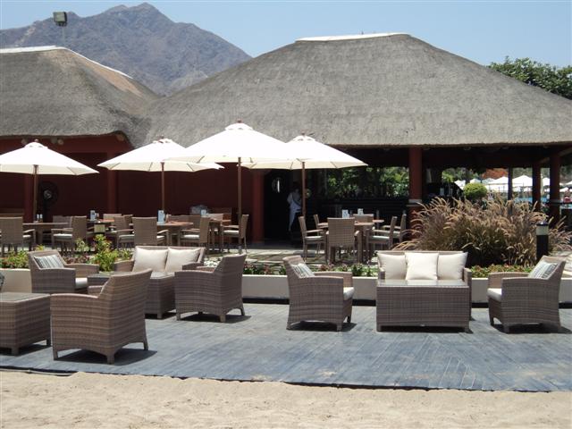 Desert Elegance – A Dubai Collaboration in Earth and Light Outdoor lounge area at a Dubai hotel featuring CG’s hand-woven four-piece sofa set in earth tones, paired with white umbrellas