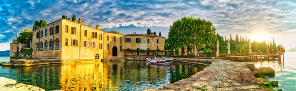 Castle by a lake with outdoor furniture and a yacht, symbolizing CG Blog’s blend of design insight, lifestyle, and professional expertise
