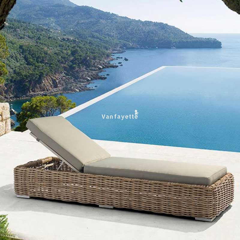 Beige round rattan chaise lounge chair beside a modern outdoor pool