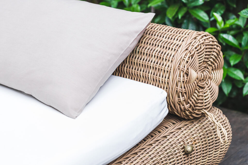 Close-up of an outdoor PE rattan sofa highlighting woven details and plush cushions.