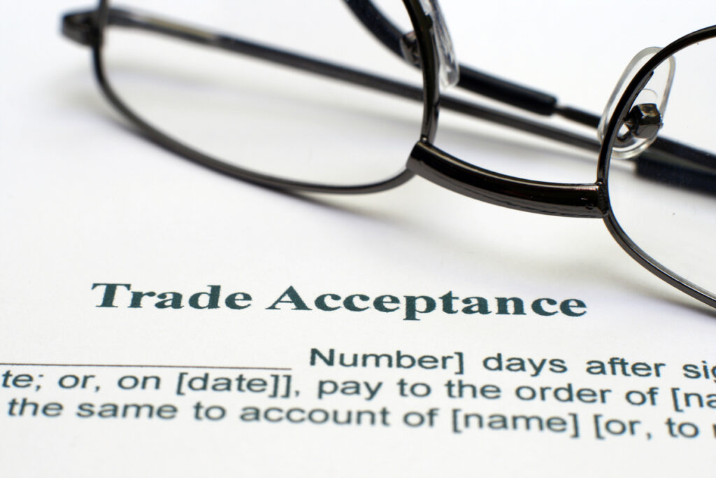 Eyeglasses placed on a desk with the word “Trade” written below.