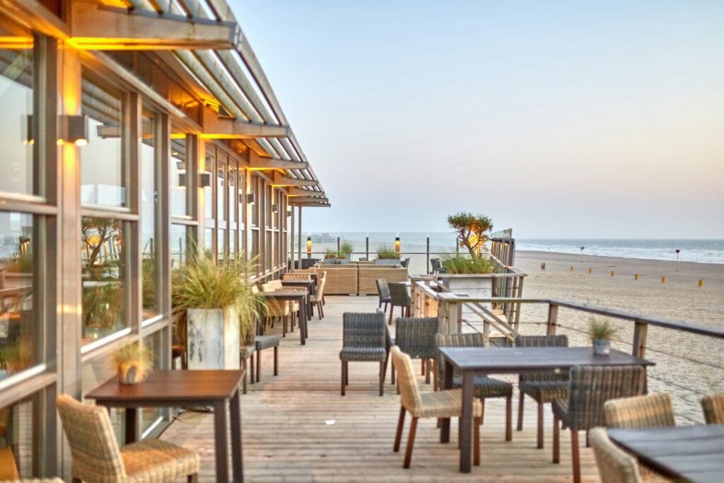 Commercial outdoor dining furniture installed on a seaside restaurant terrace, showing durable tables and chairs designed for long-term use in high-traffic hospitality environments.