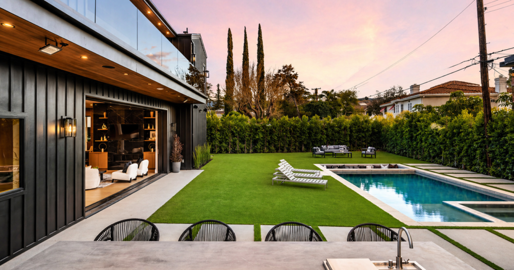 Outdoor poolside furniture featuring dining table with chairs and lounge daybeds arranged beside a swimming pool in a luxury resort setting