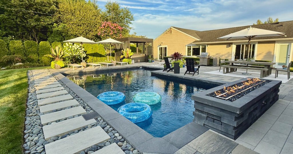 high-end swimming pool area decor with fireplace, lounges, umbrellas