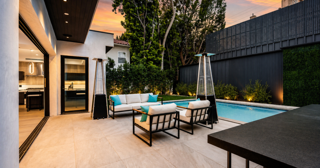 Outdoor sofa set placed beside a pool featuring modern cushions and a relaxed luxury poolside seating area