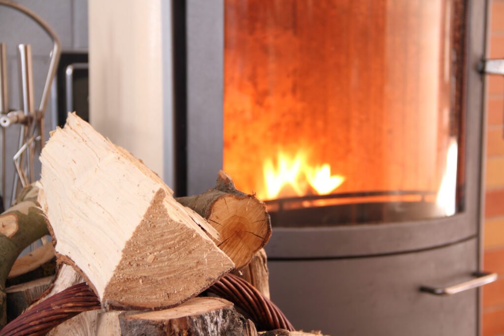 Prepare Fireplace Inventory Before Peak Winter Demand Wood-burning fireplace with stacked firewood representing seasonal winter demand and the importance of planning fireplace inventory before peak season.