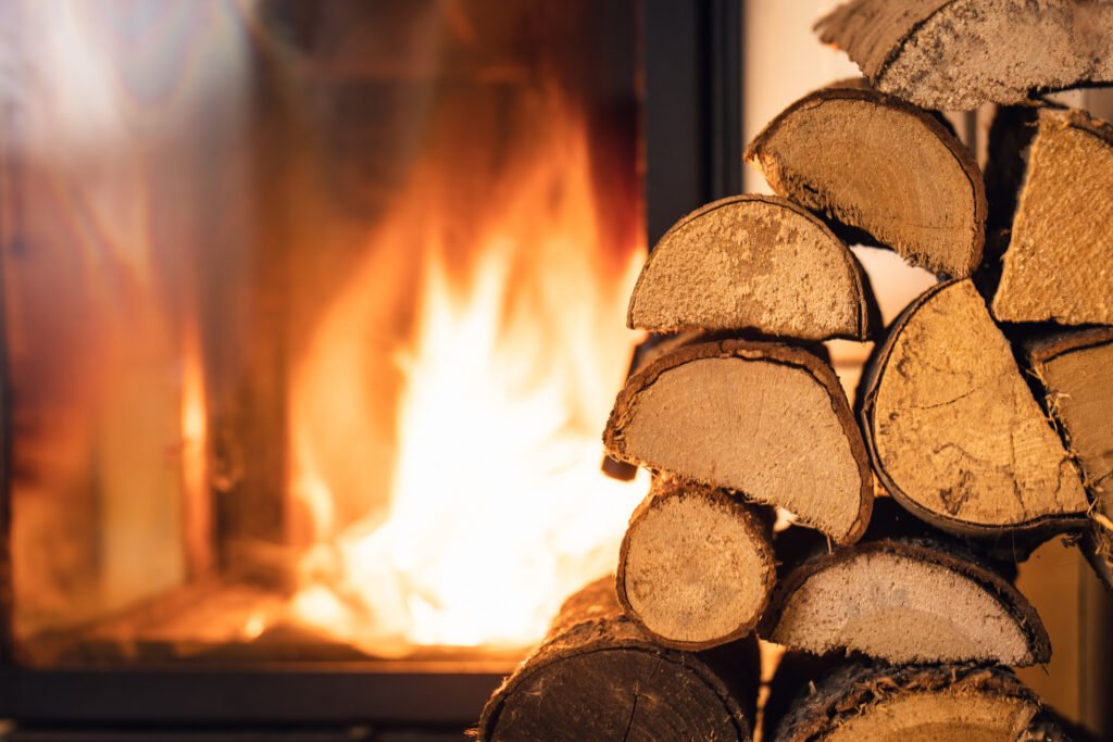 Burning indoor fireplace with stacked firewood, representing peak winter fireplace demand and the importance of planning inventory ahead of the season.